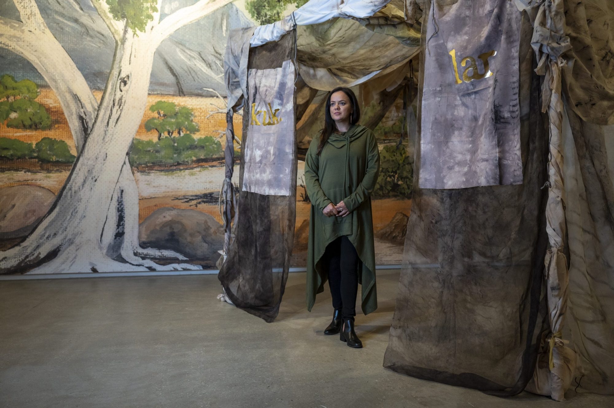 Stacie Piper standing in Paola Balla's 'Murrup (Ghost) Weaving in Rosie Kuka Lar (Grandmother’s Camp)' 2021. Installation view (detail), Tarrawarra Museum of Art. Photograph: T. J. Garvie